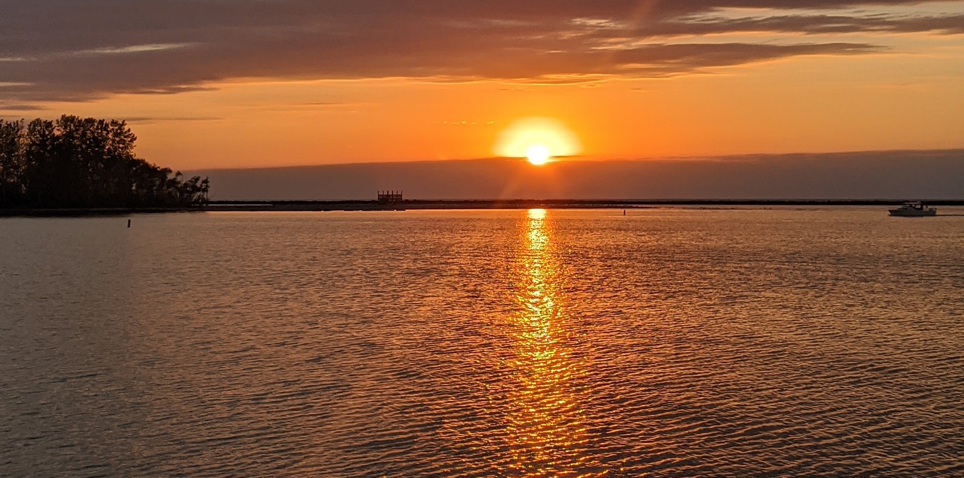 Sunset over Lake Erie, with the sun setting on the horizon and a golden reflection across the water